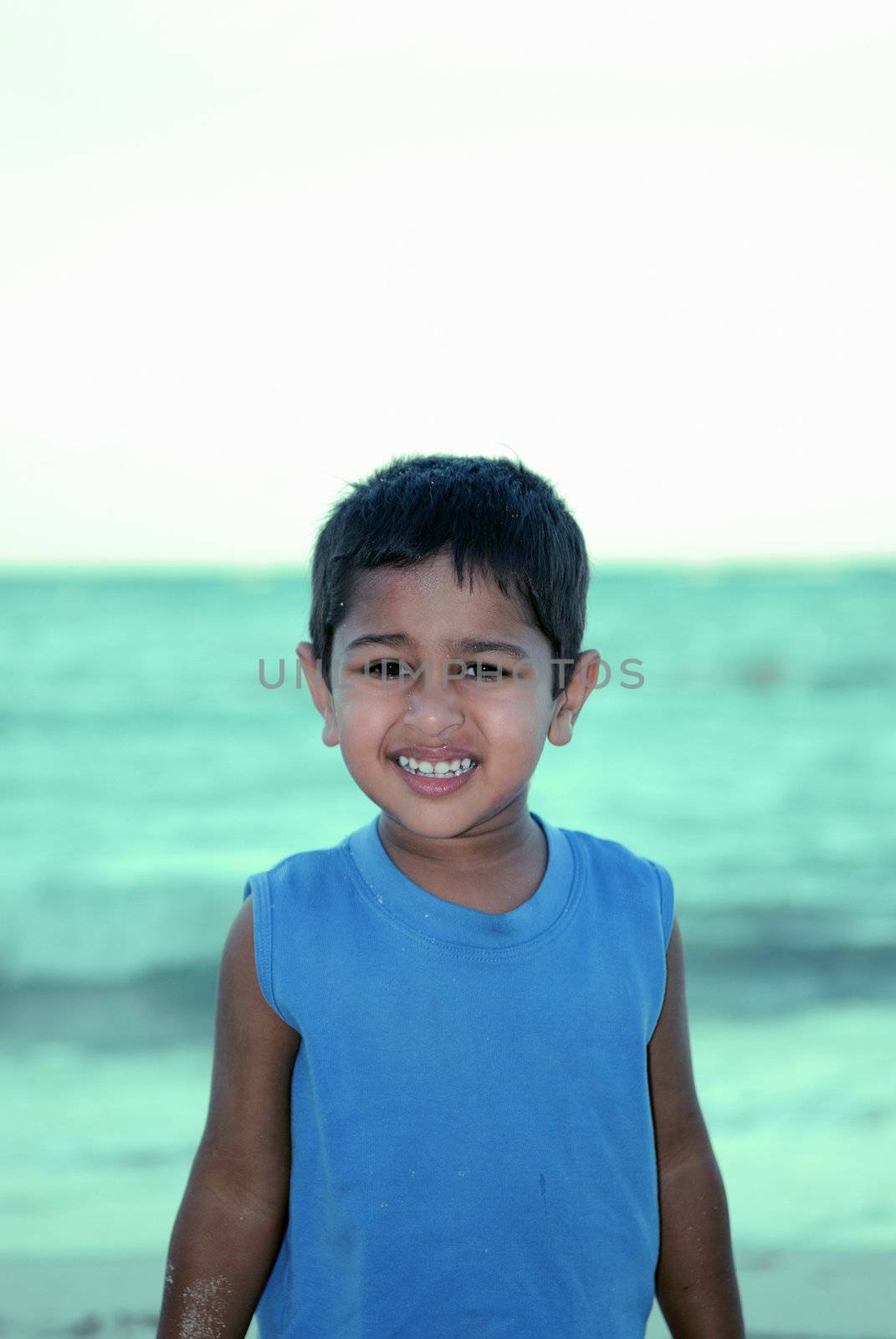 An handsome Indian kid ready to swim by the pool