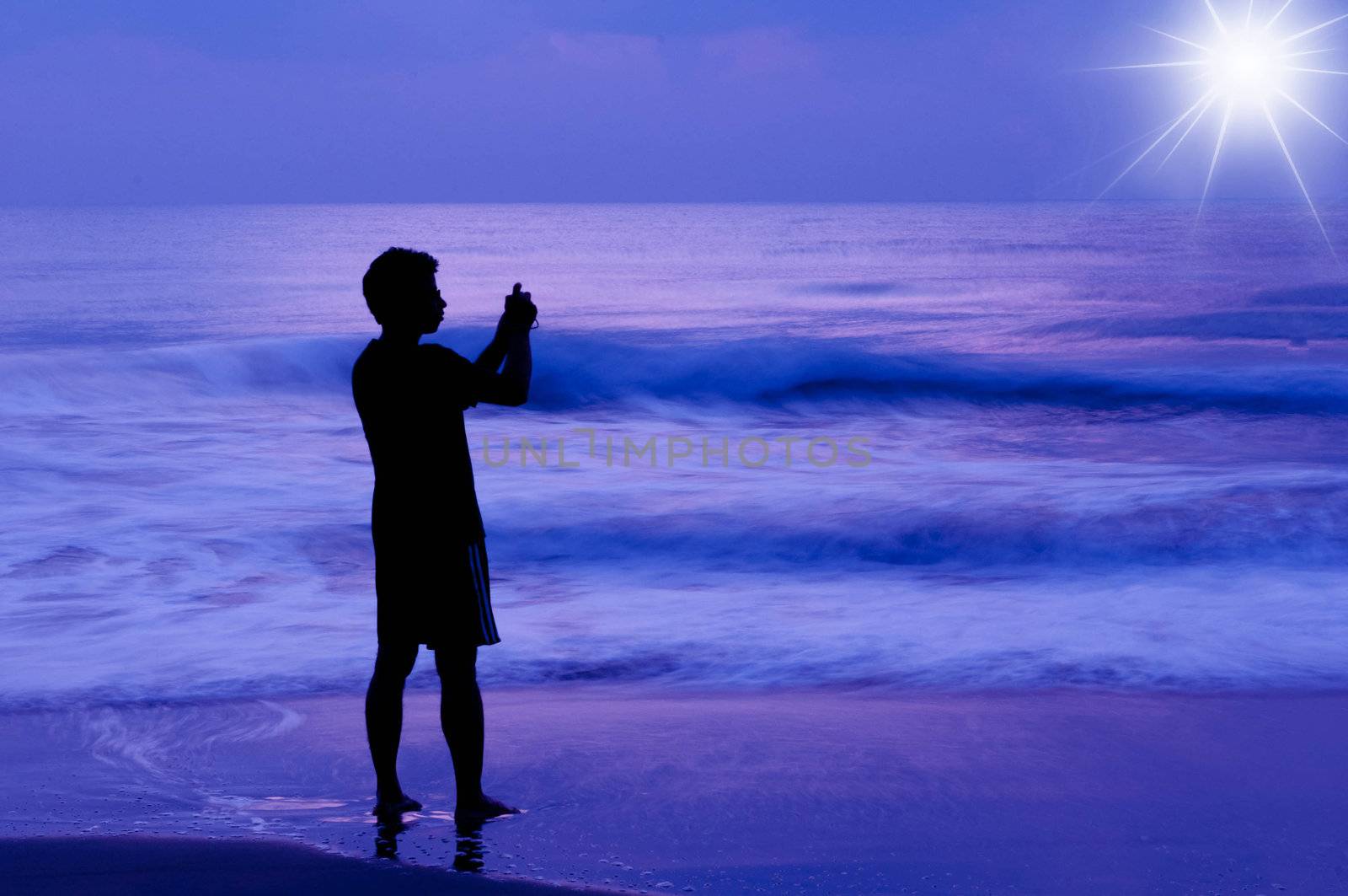 An avid photographer taking picture of the sunrise at the sea