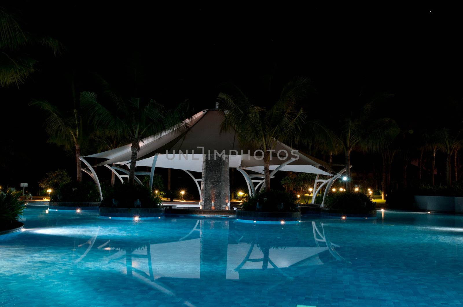 A pretty swimming pool in night at a local resort