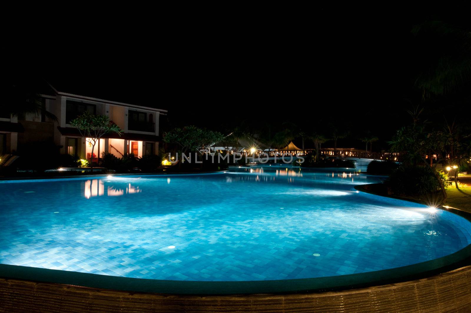 A pretty swimming pool in night at a local resort