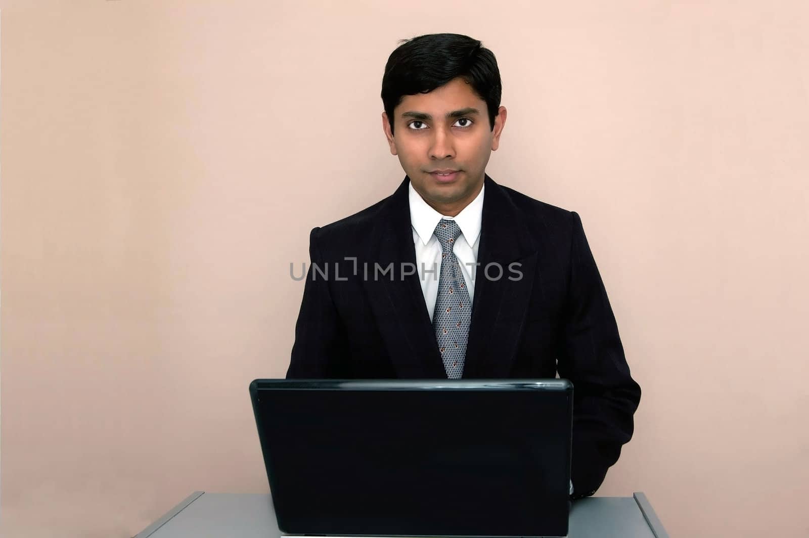 An handsome Indian businessman working on a laptop