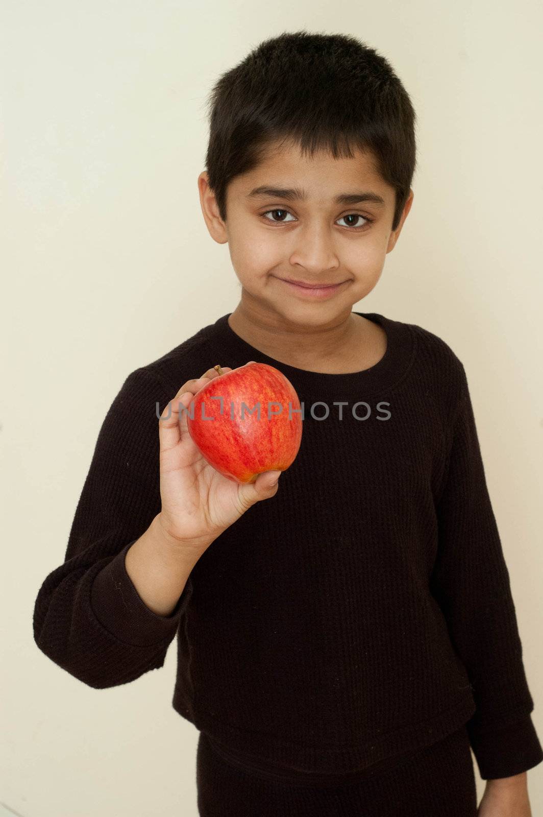 an handsome indian kid holding apple by pazham