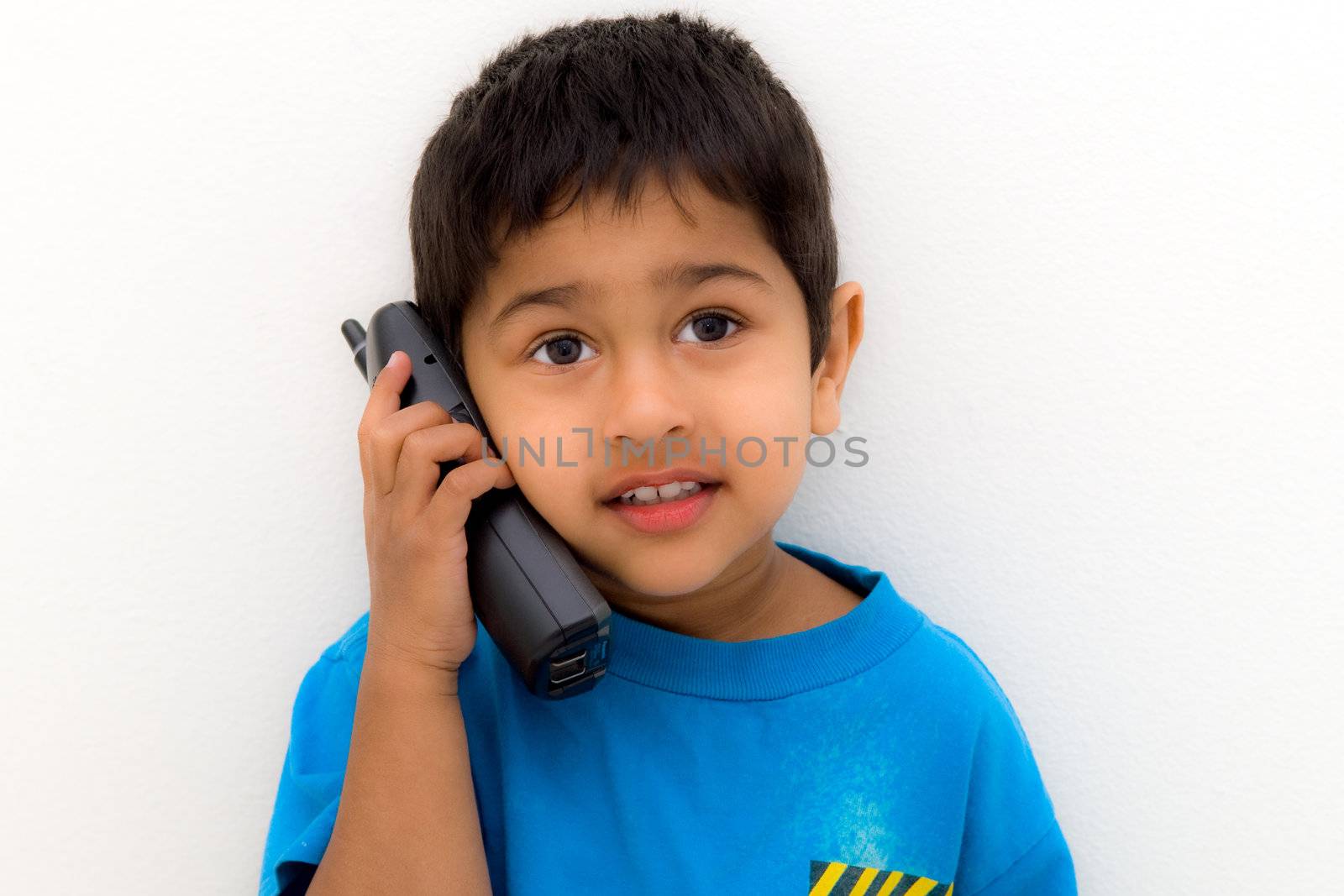 Handsome Indian kid speaking on a handset