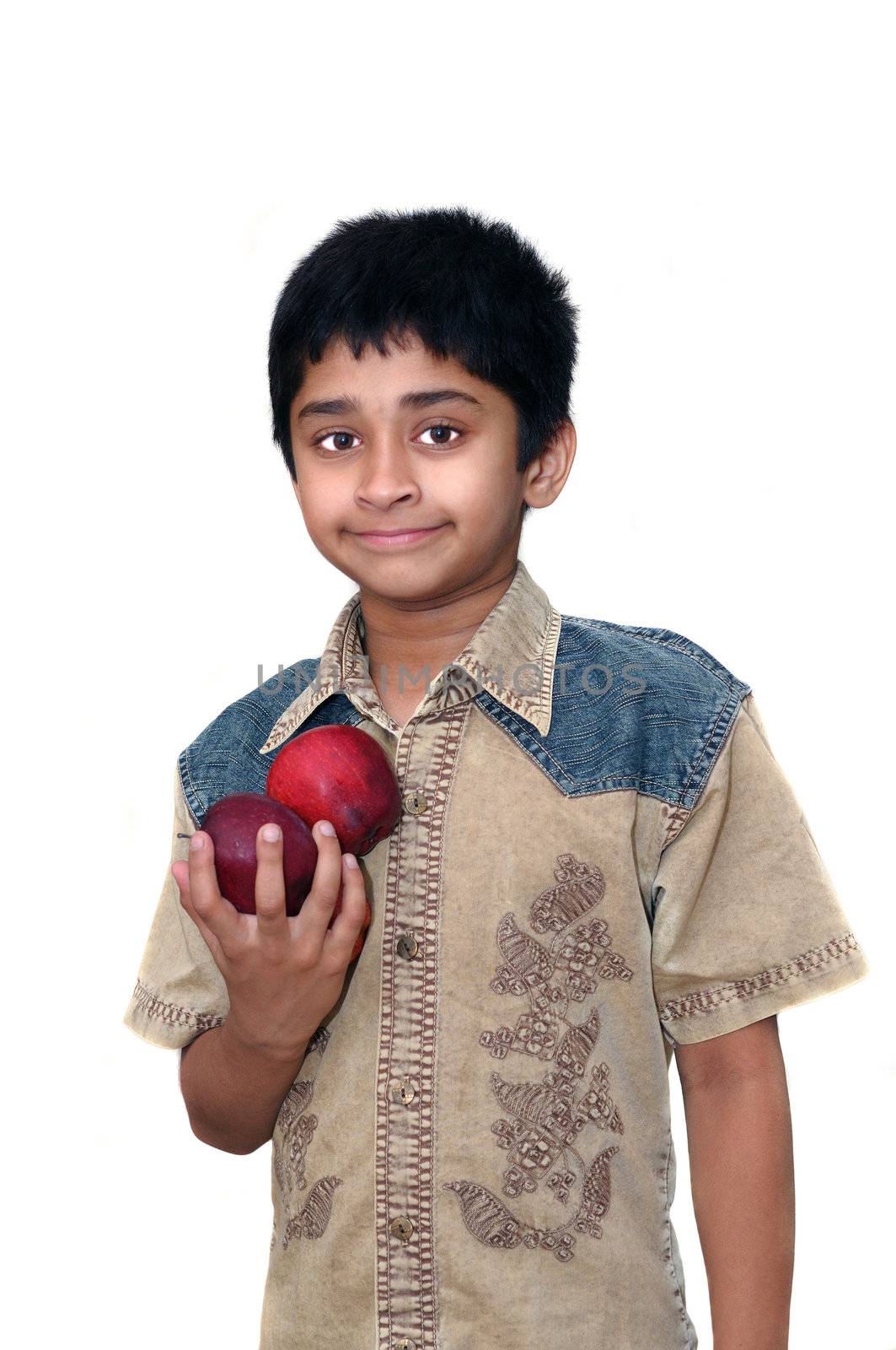 An handsome Indian klid holding apples to eat