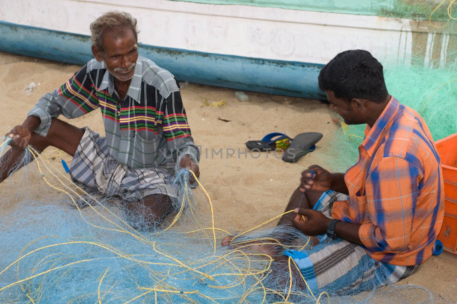 CHENNAI, INDIA - JUN 6: Fisherman weaving nets in the Indian coastline and getting ready to ctch fish for the holidays on June 6, 2009 in Chennai, India