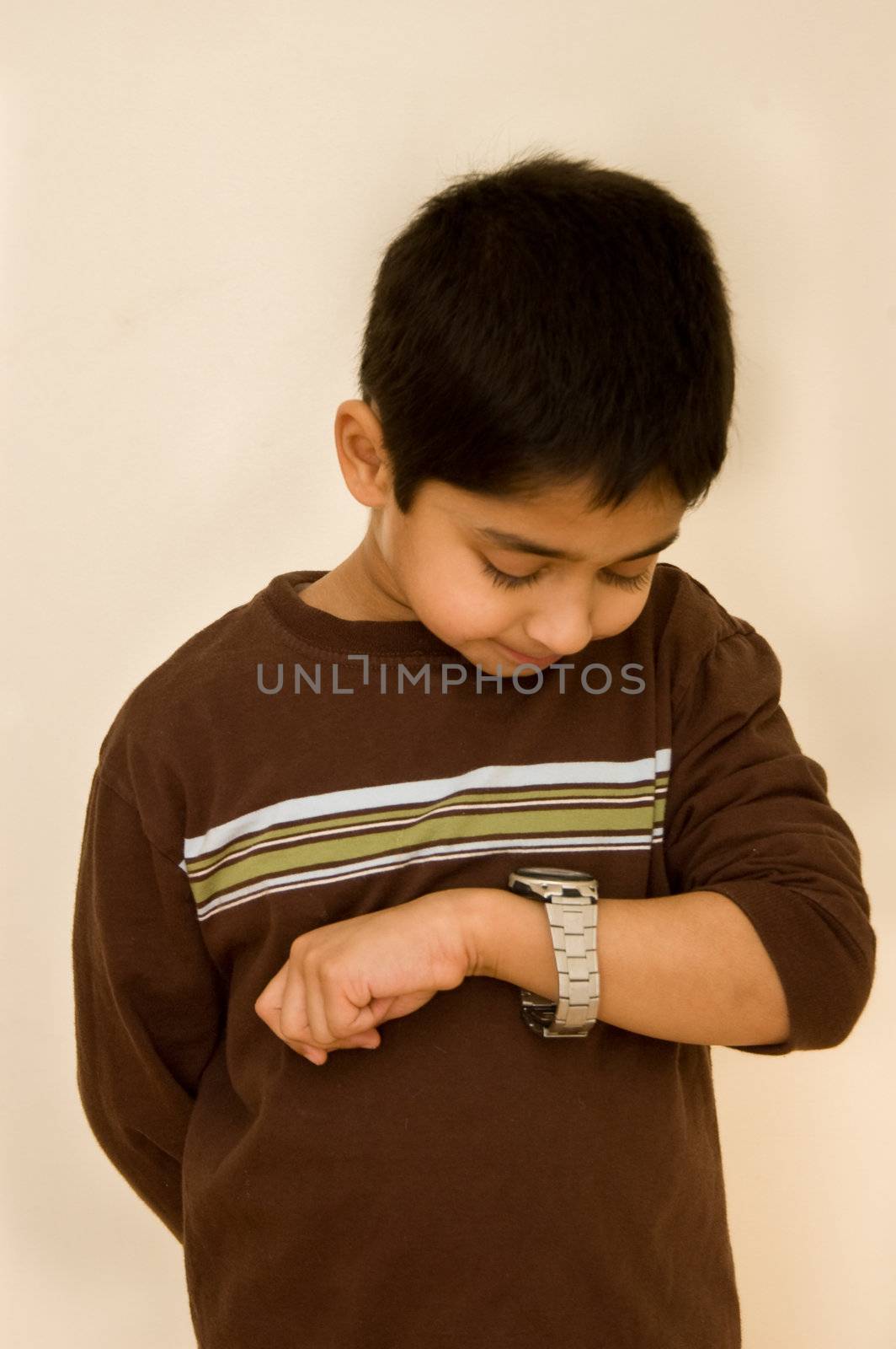 An handsome indian kid keeping track of time by pazham