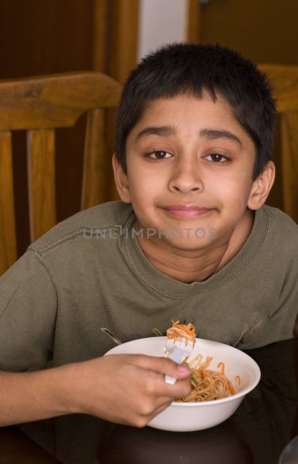 Handsome Indian kid happy eating noodles