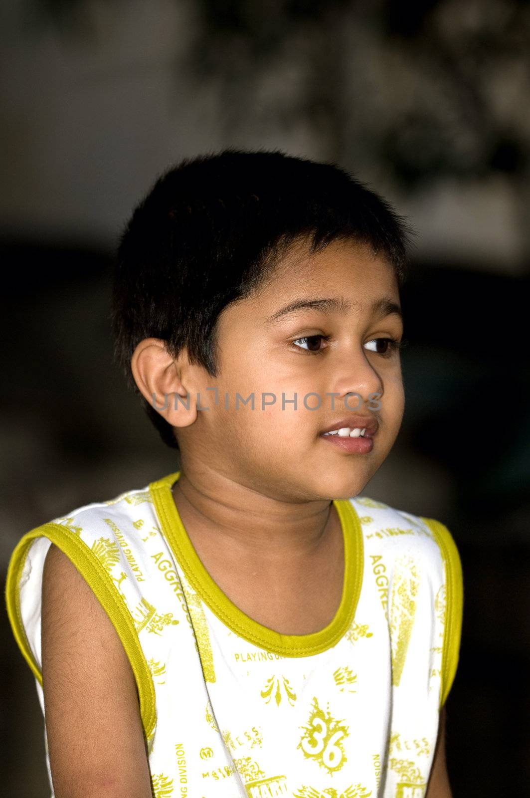 an handsome indian kid looking very thoughtful by pazham