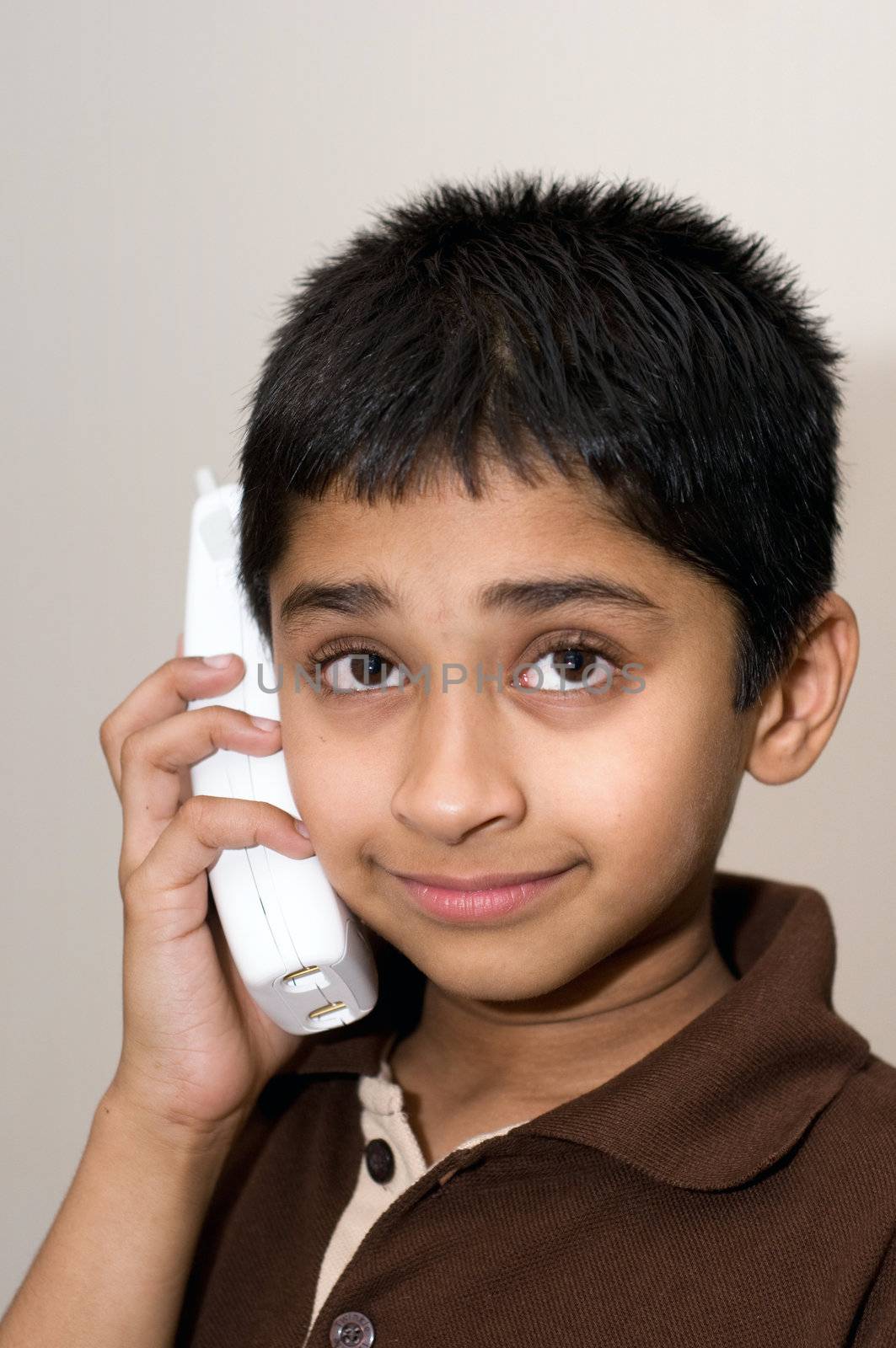 An handsome Indian kid talking on the phone by pazham