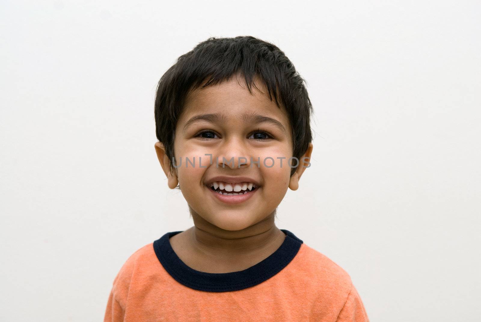 An handsome Indian kid smiling at the camera