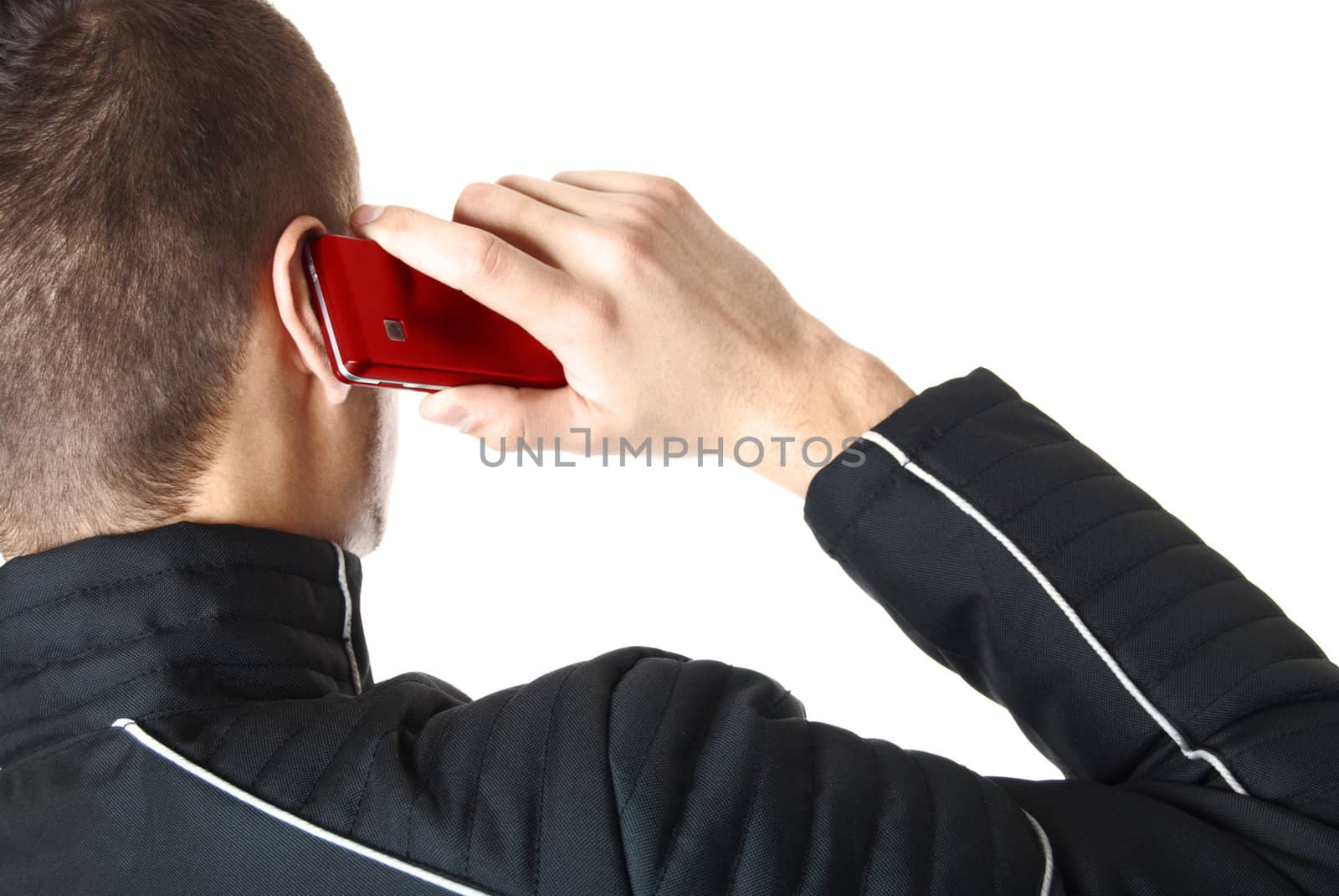 Studio shot from the back of the young metrosexual man with short hairs. He wears futuristic jacket and talks on red smart phone. Isolated on white background