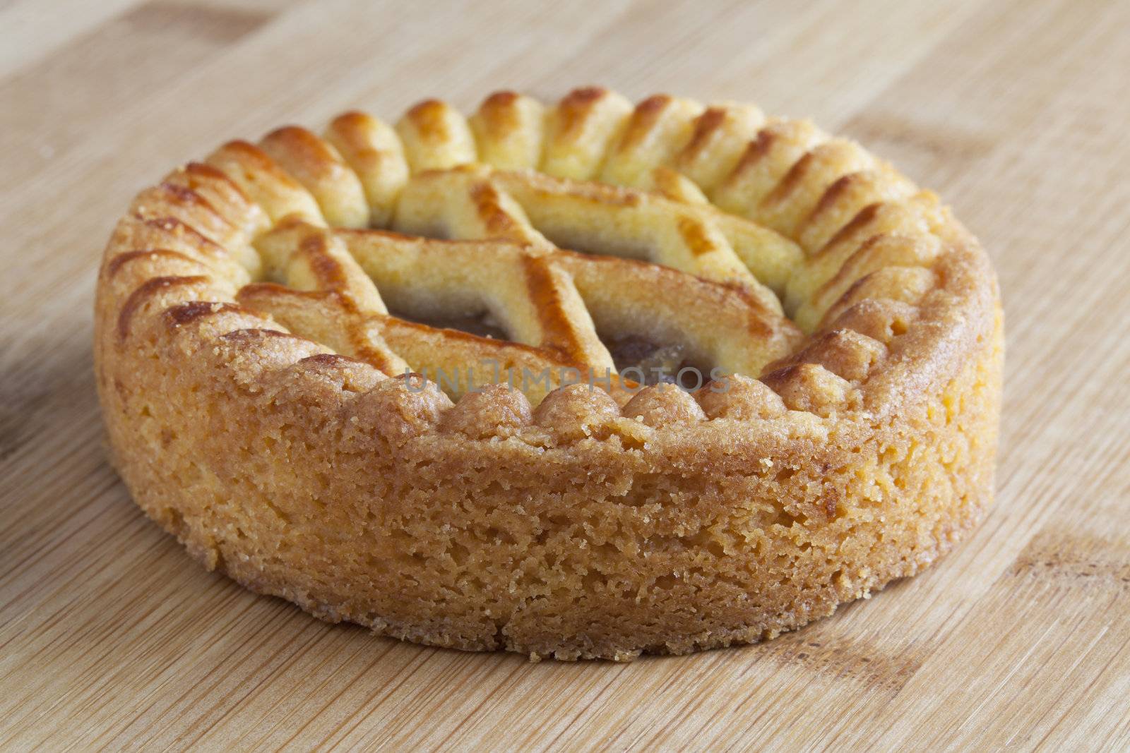 Small apple pie on wooden work surface.