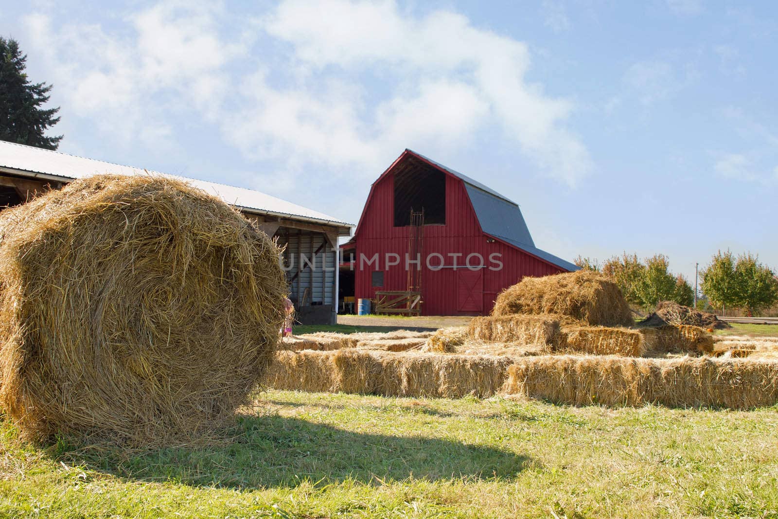 Roll of Hay by the Red Barn with Blue Sky