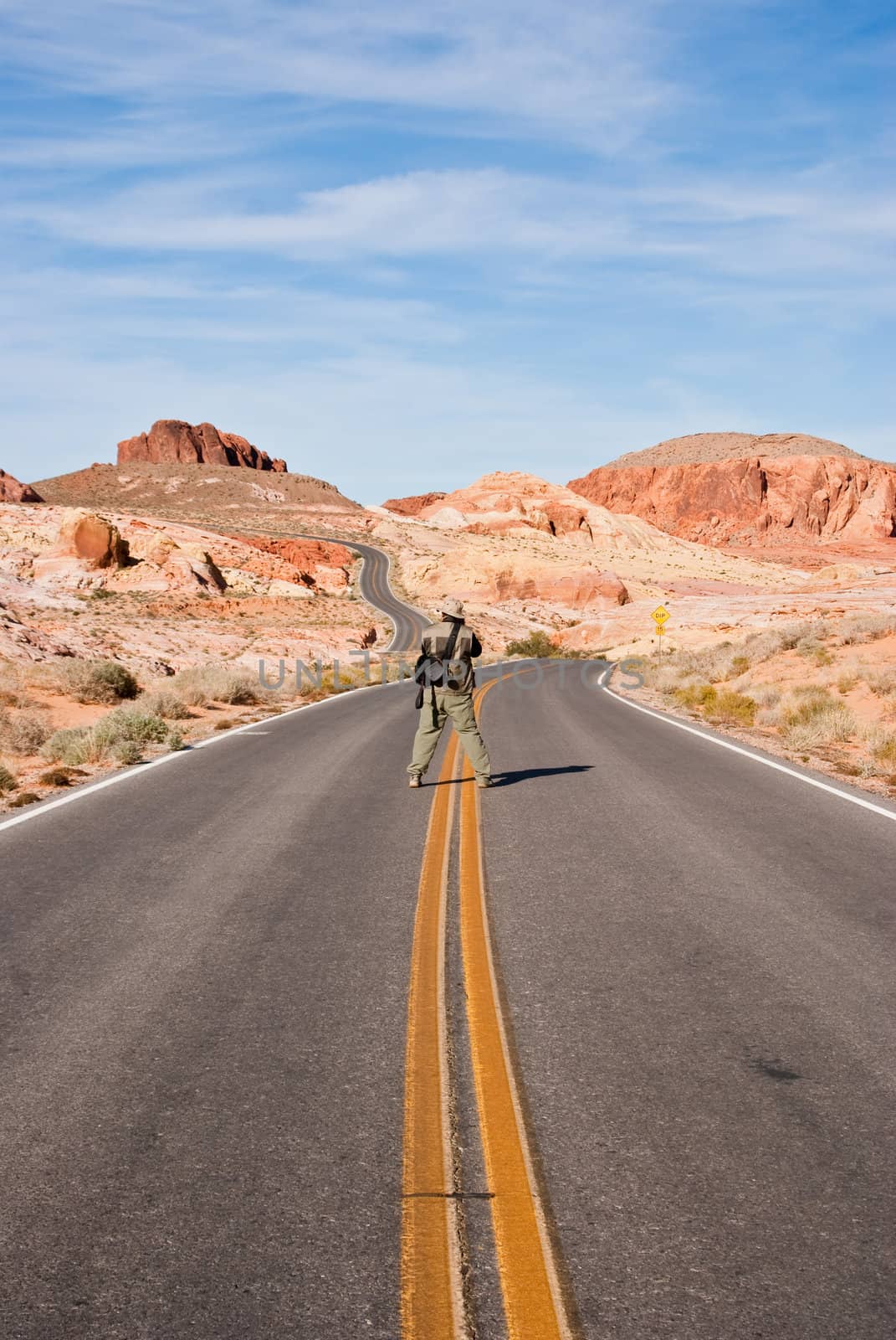 Man in middle of road looking for perfect shot in Valley of Fire, USA