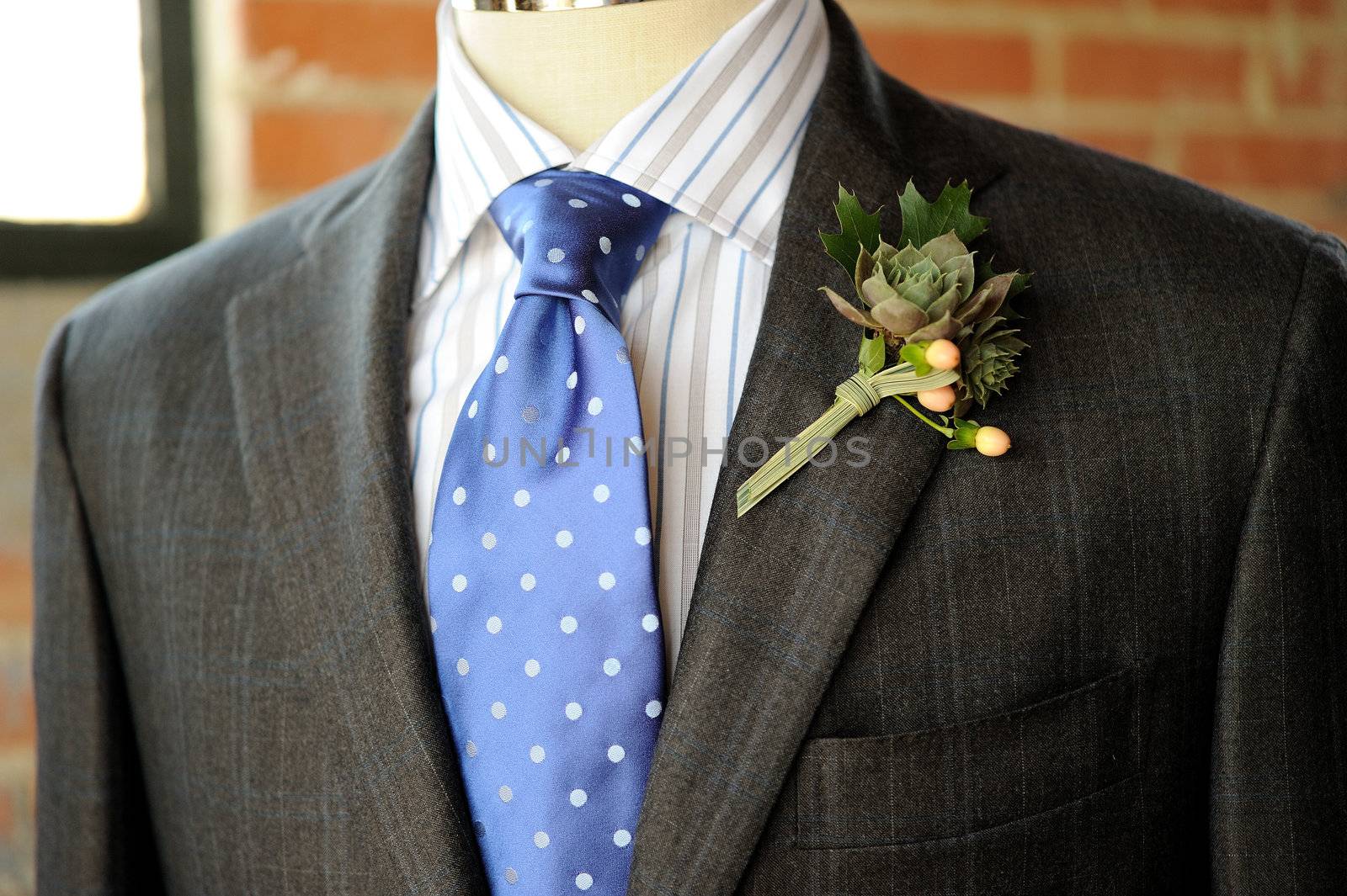 Image of a gray suit with blue tie and boutonniere