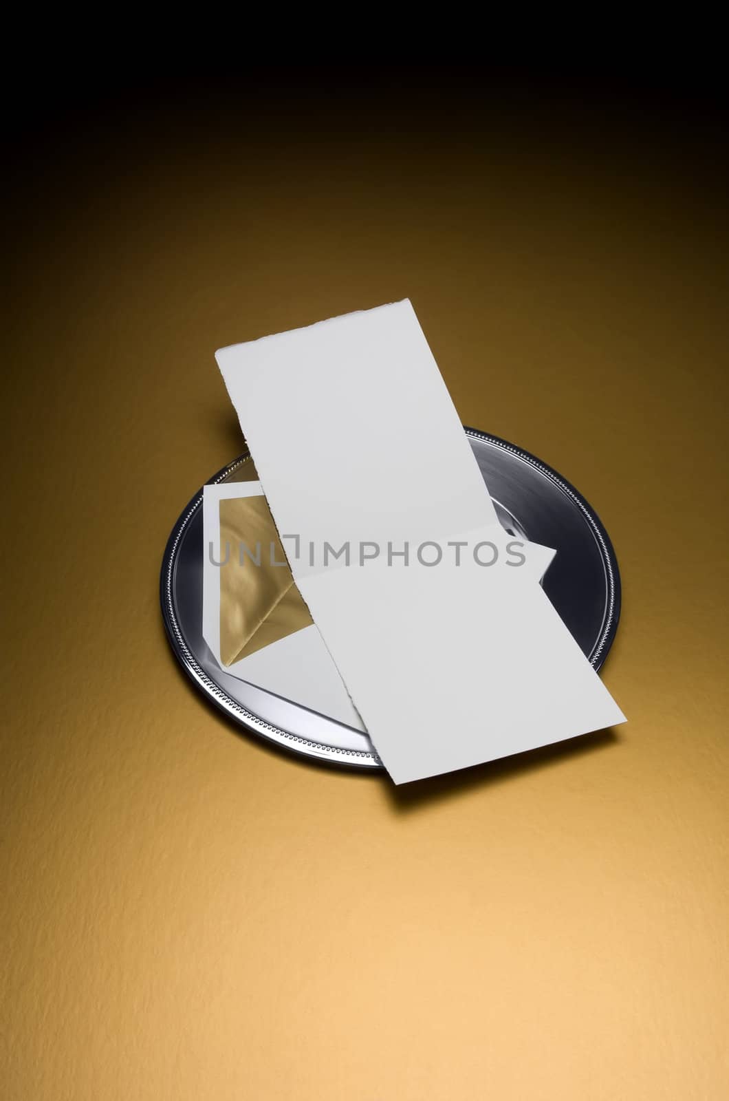 Image of a Blank Invitation with envelop on silver tray and gold background