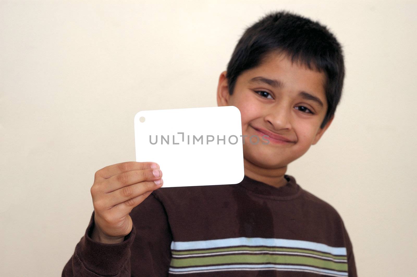 An handsome Indian kid holding a signboard