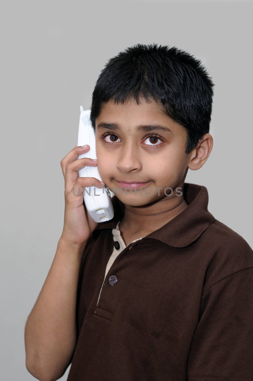 An handsome Indian kid talking on phone