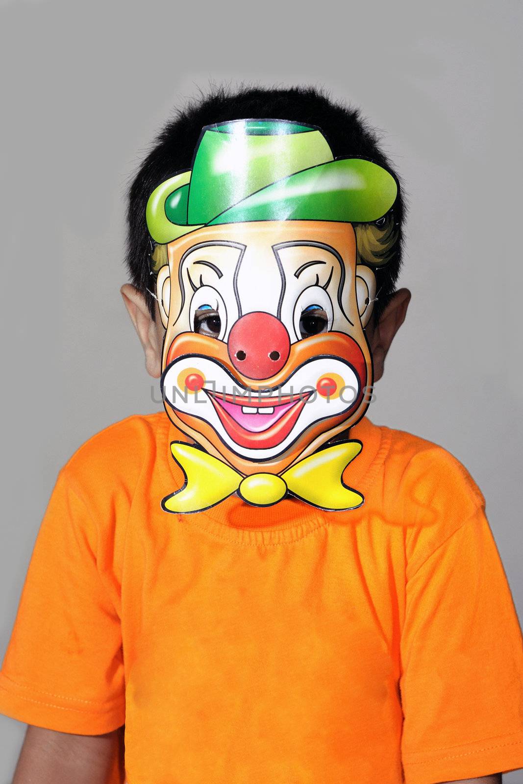 A kindergarten kid wearing a clown mask