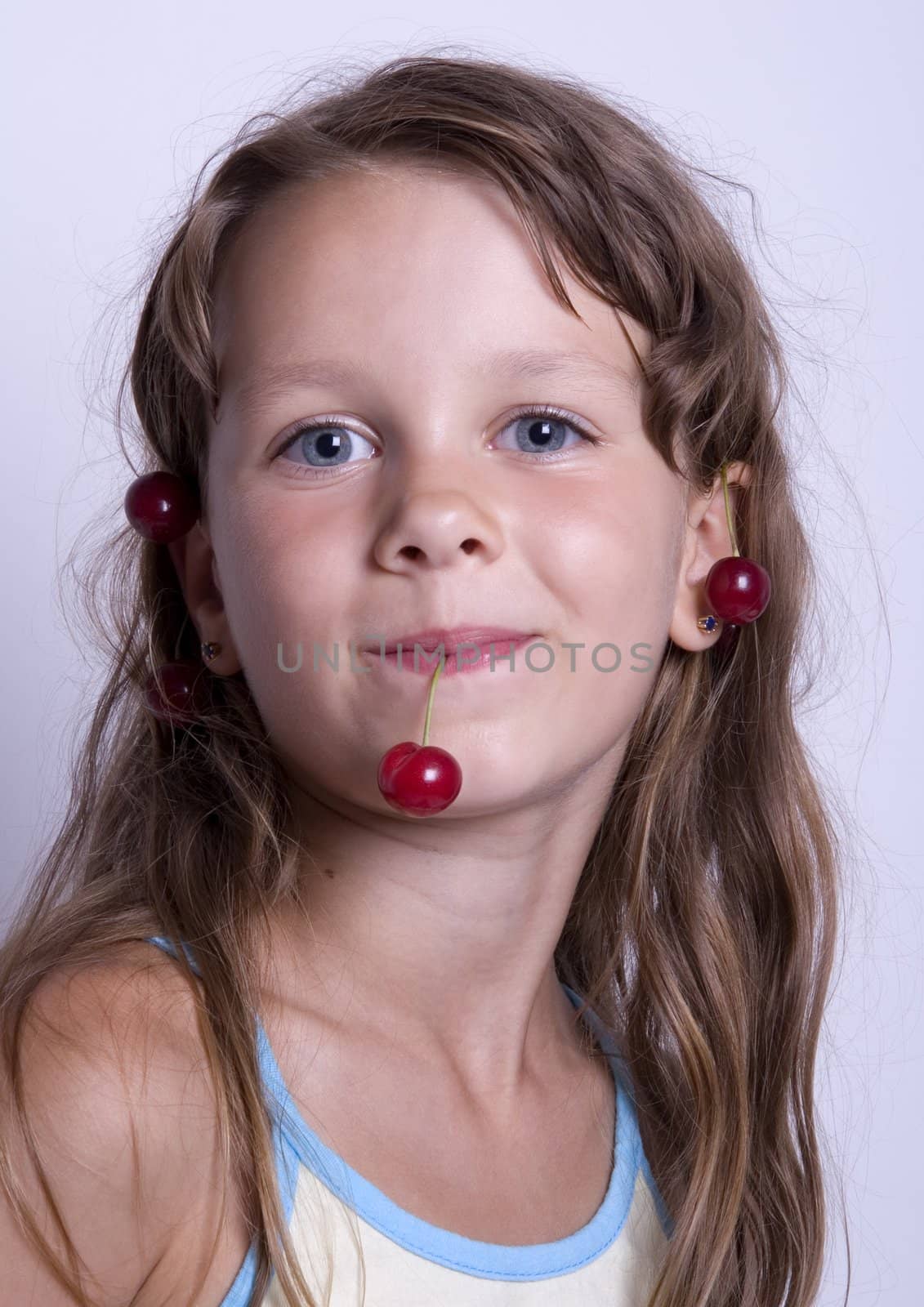 A sweet young girl eating fresh fruit. The child is on a white background