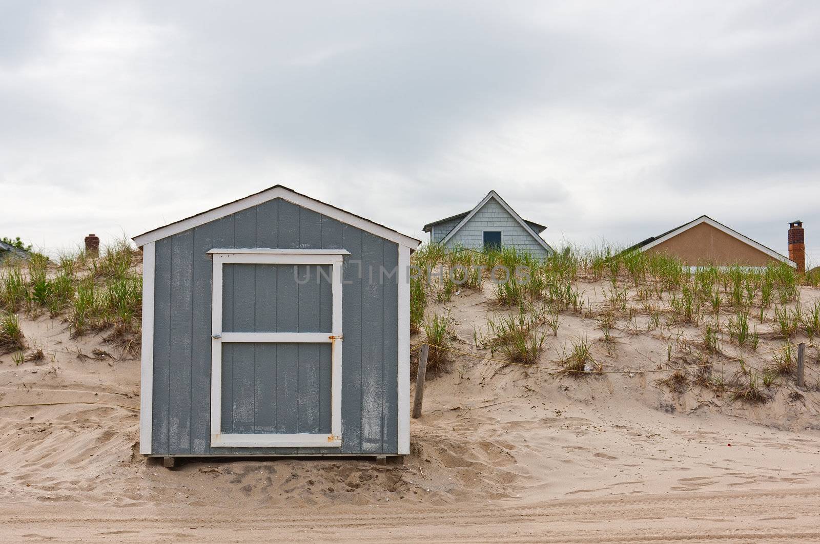 A storage shed in front of dunes on a beach