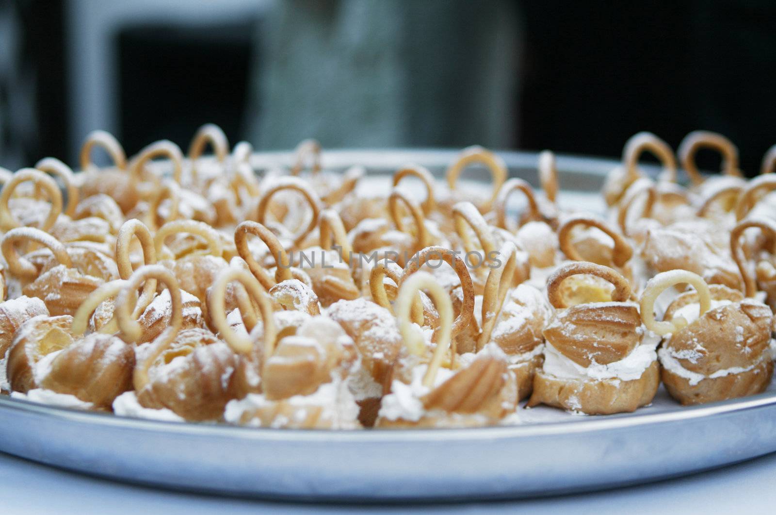 Small delicious wedding cakes with sugar powder on plate.