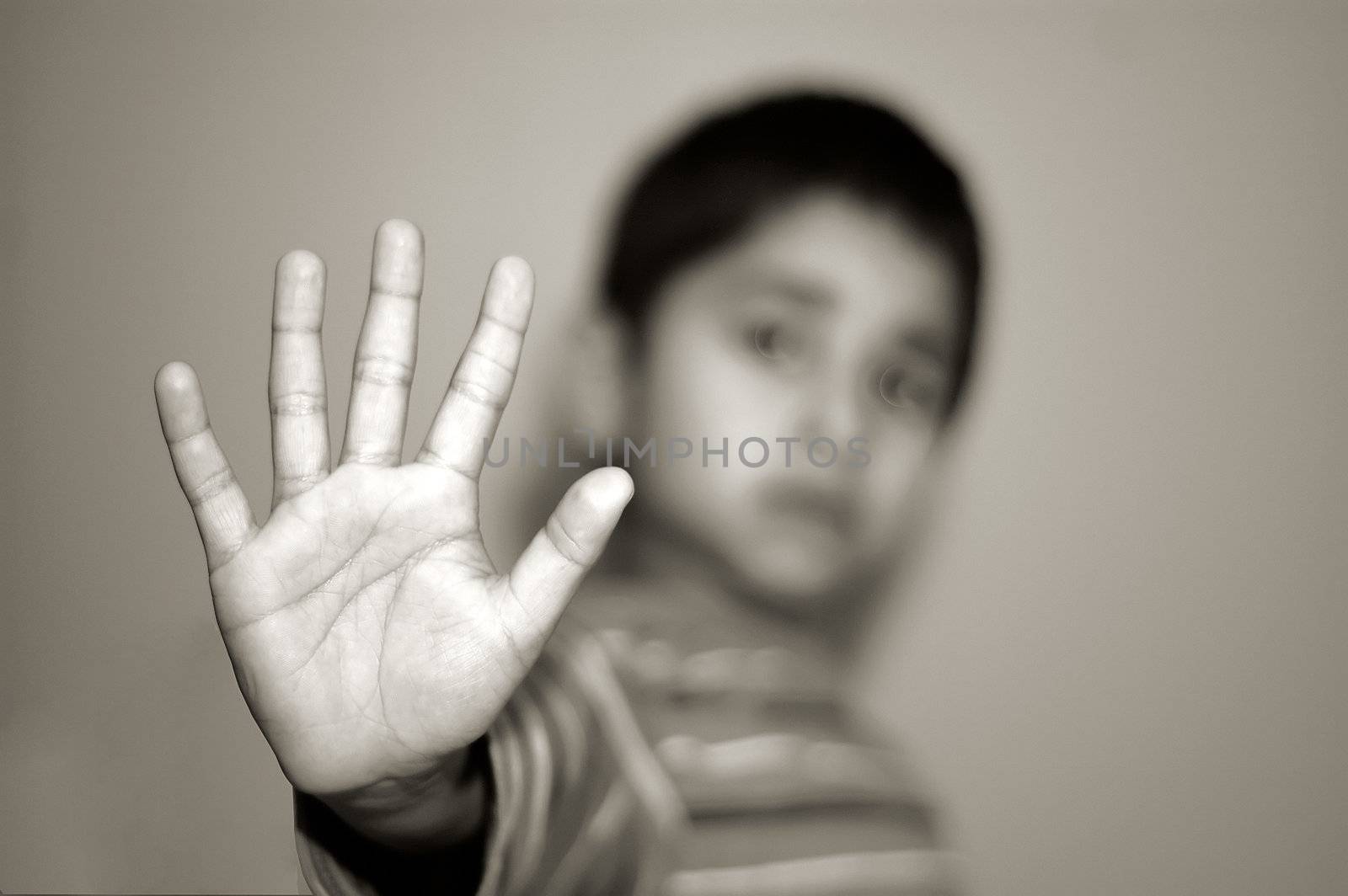 An handsome Indian kid holding a stop sign