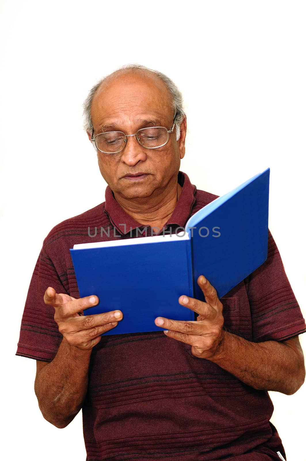 Old Indian Immigrant reading a blue book