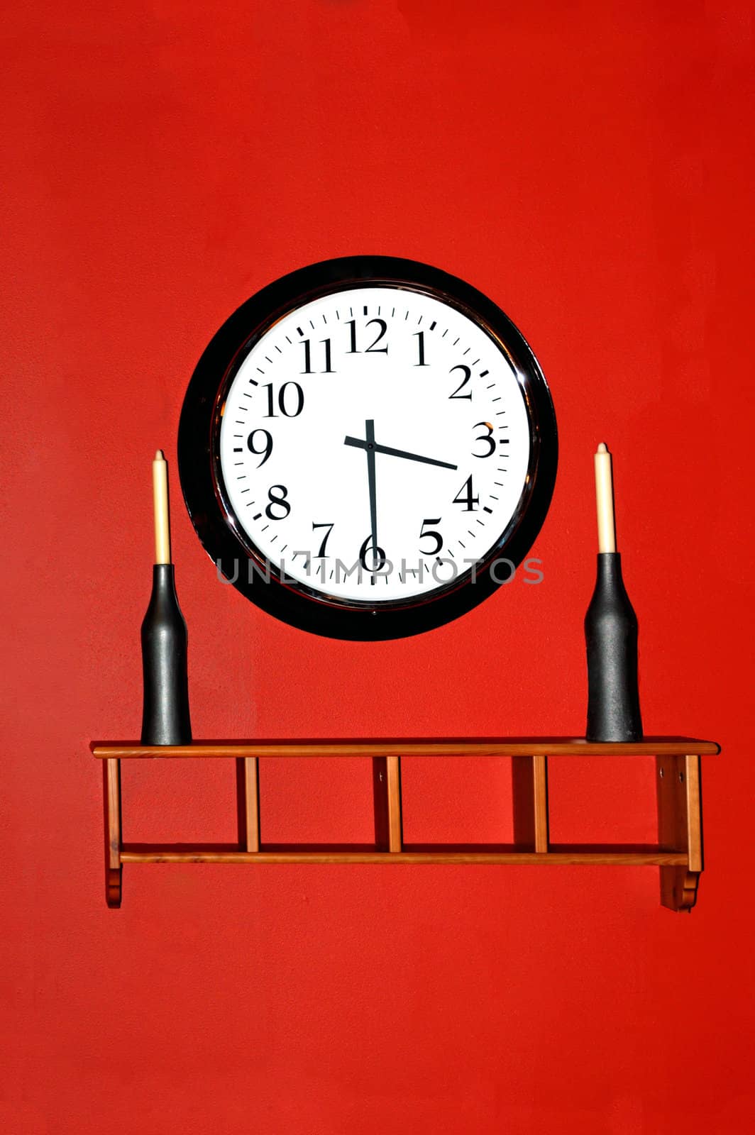 A beautiful walkl clock hanging against a red wall