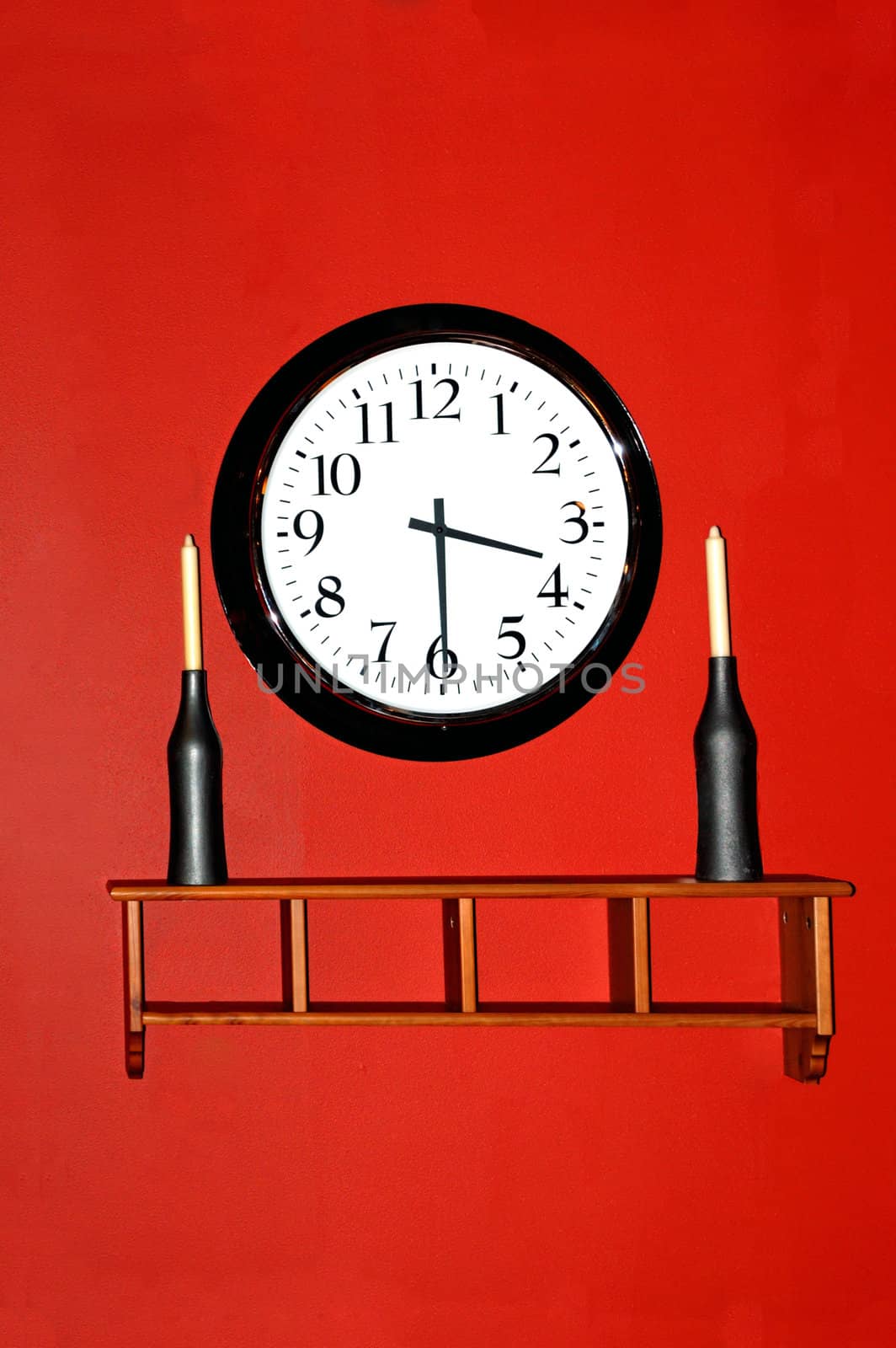 A beautiful walkl clock hanging against a red wall