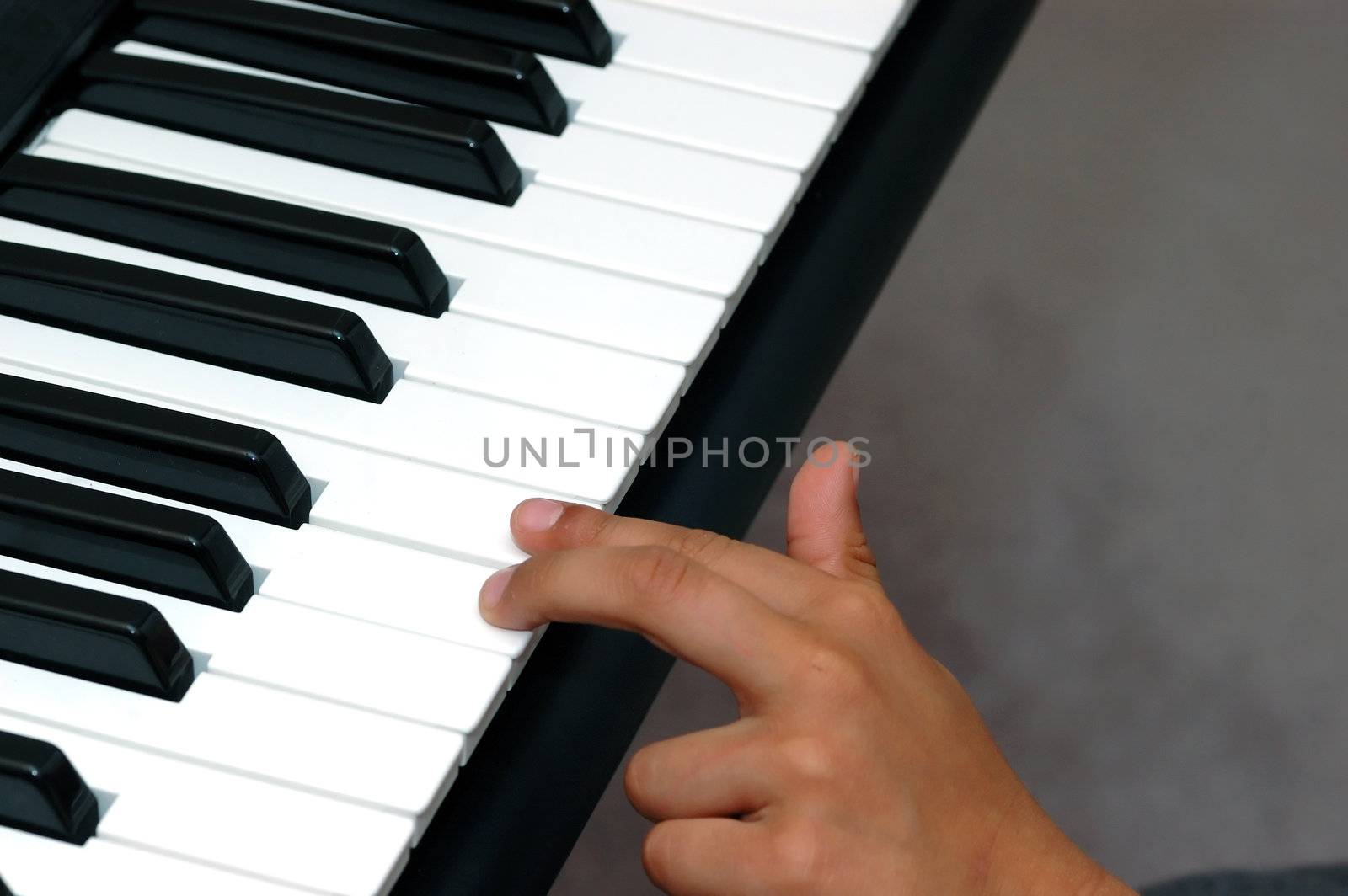 Young hands playing the keys on a piano