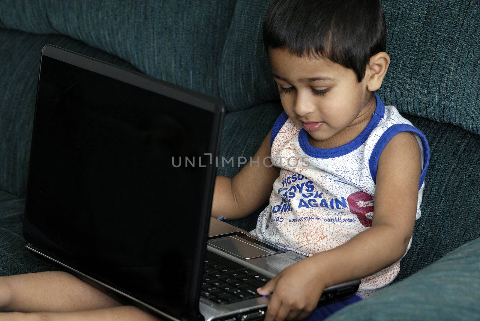 Handsome Indian kid learning using his laptop