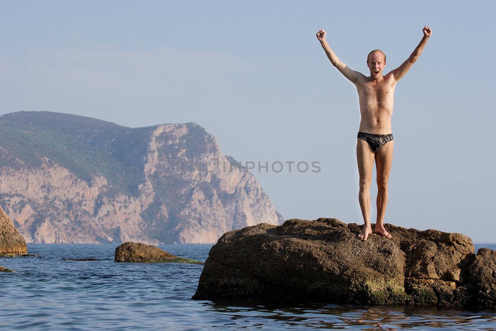 Man standing on a cliff in the sea