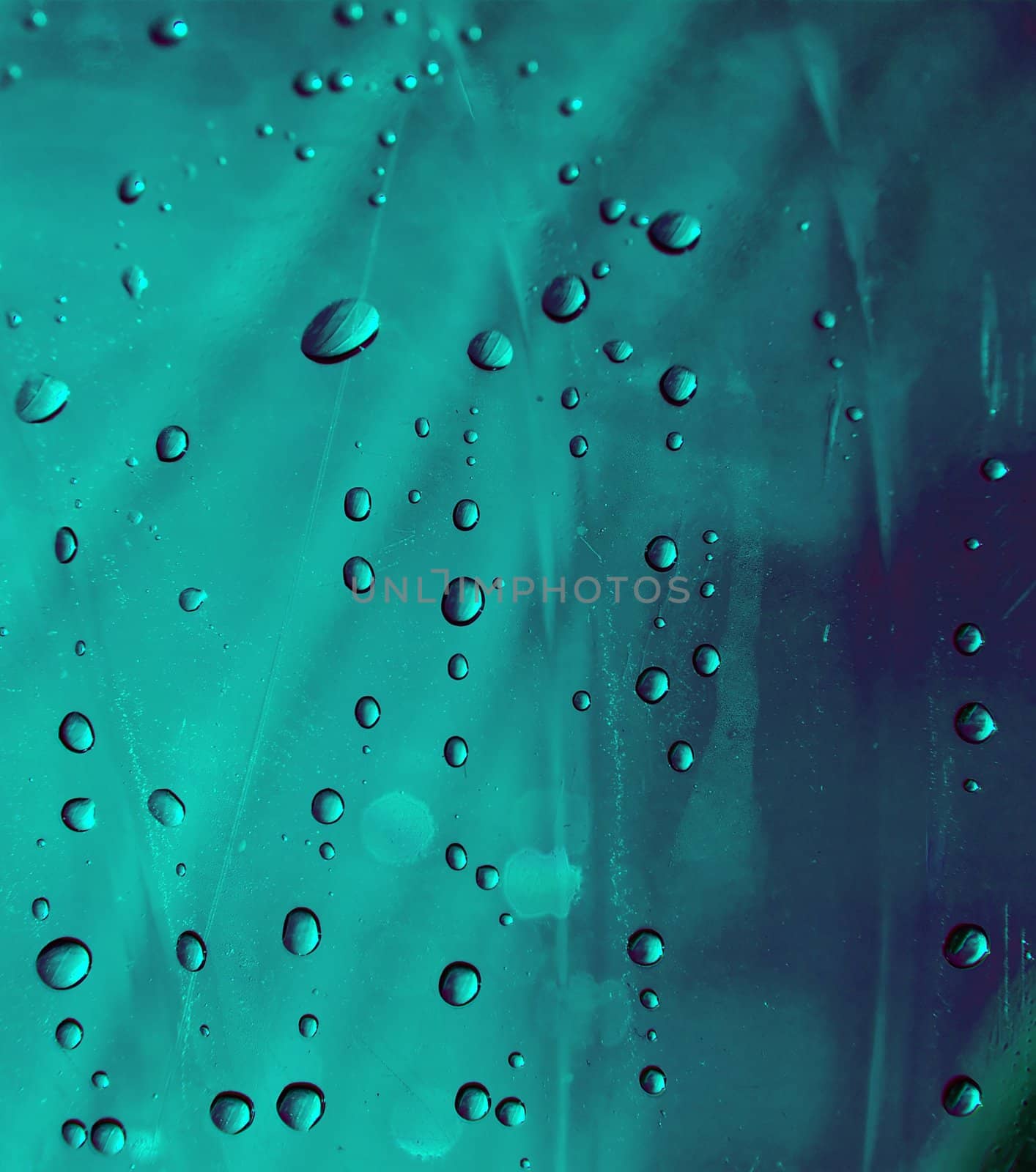 Many small water droplets on a bluish green surface