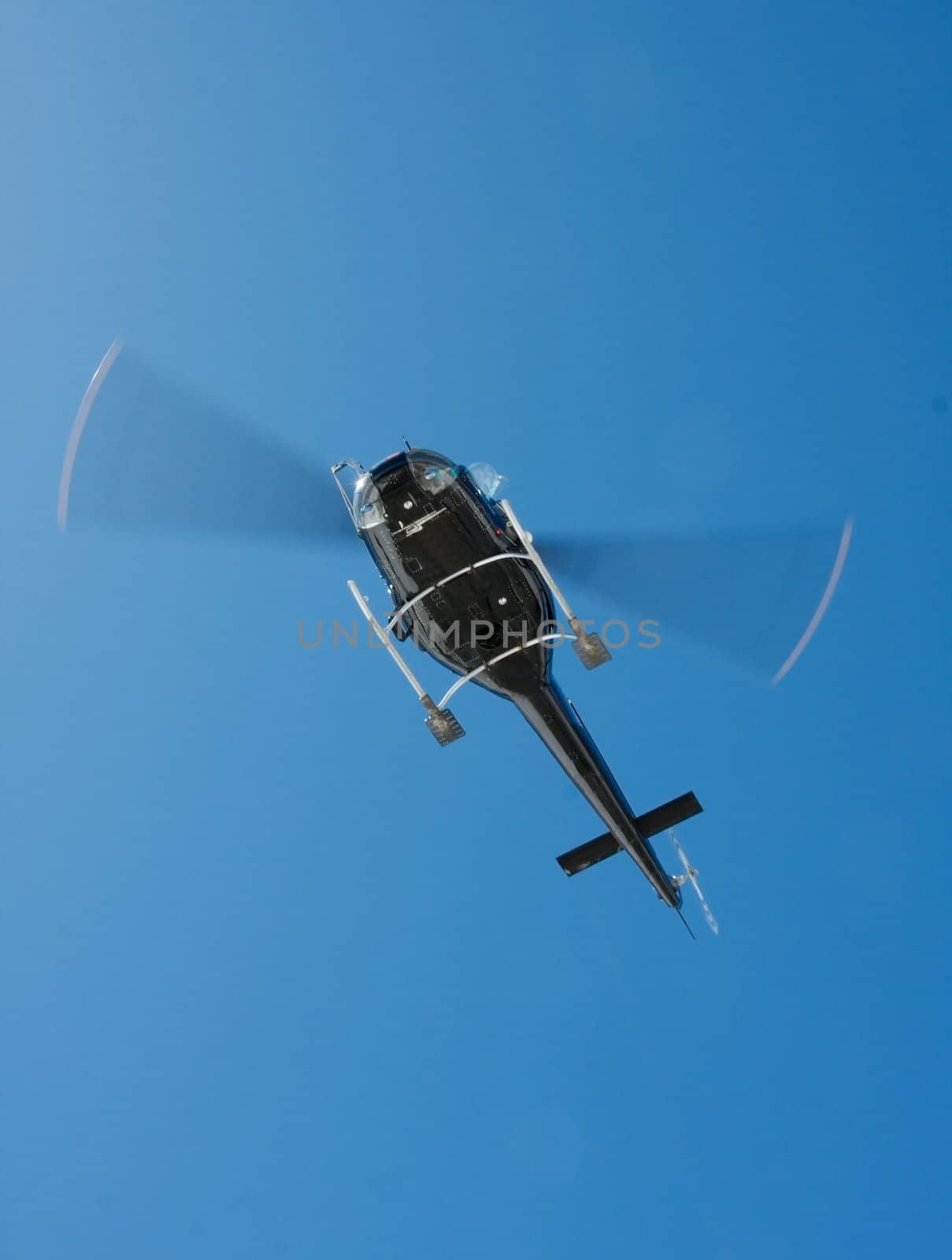 Black helicopter against clear blue sky