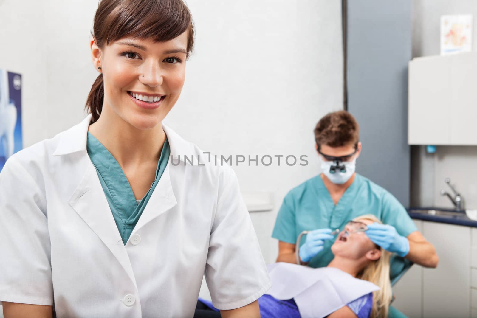 Assistant with dentistry work in the background by leaf