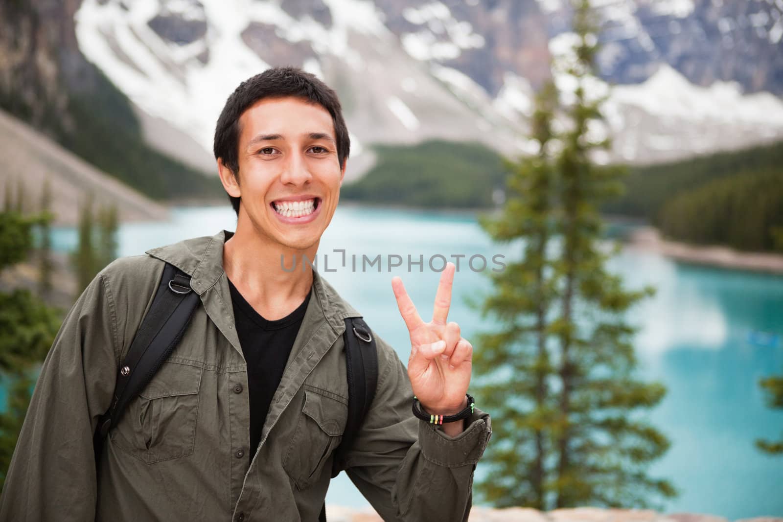 Male hiker showing you the 'V' sign by leaf
