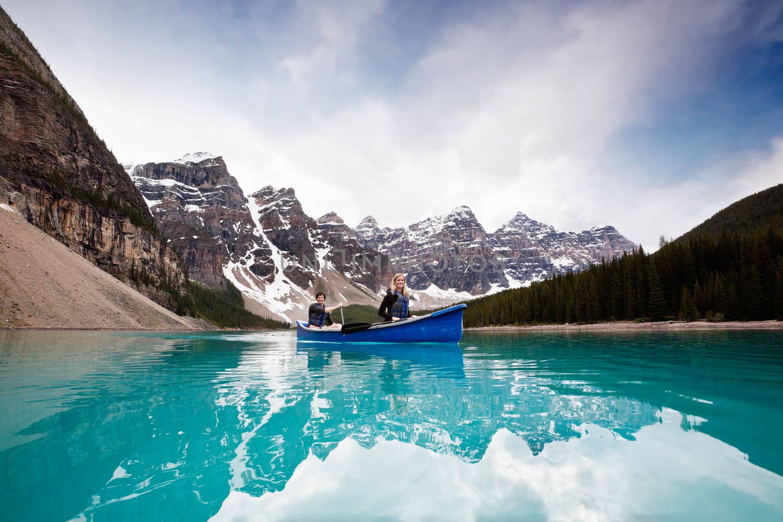 Scenic shot of couple sailing on calm water by leaf