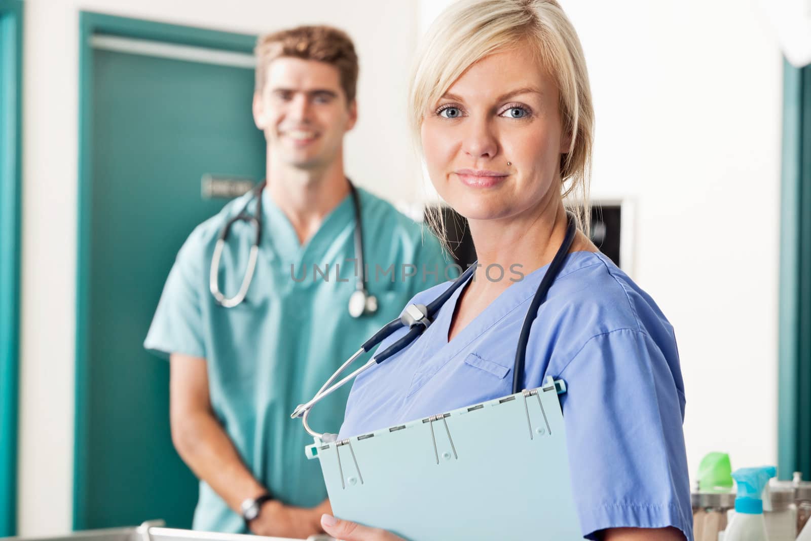 Confident female and male veterinarian by leaf