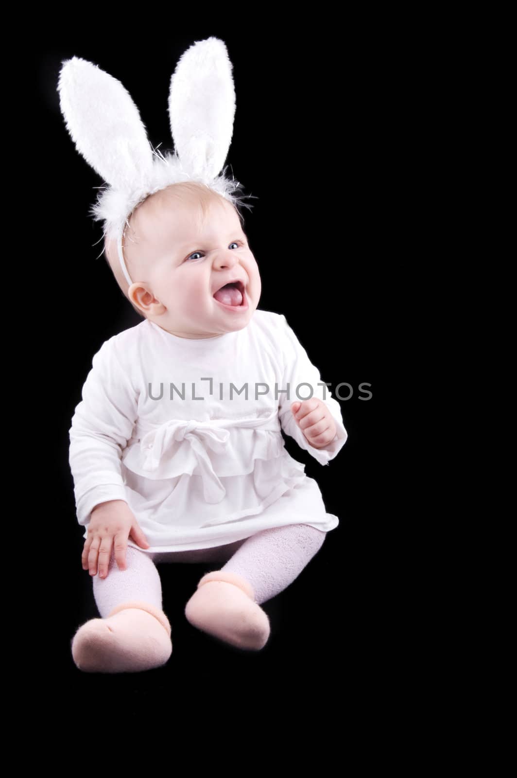 Funny baby in bunny costume on black