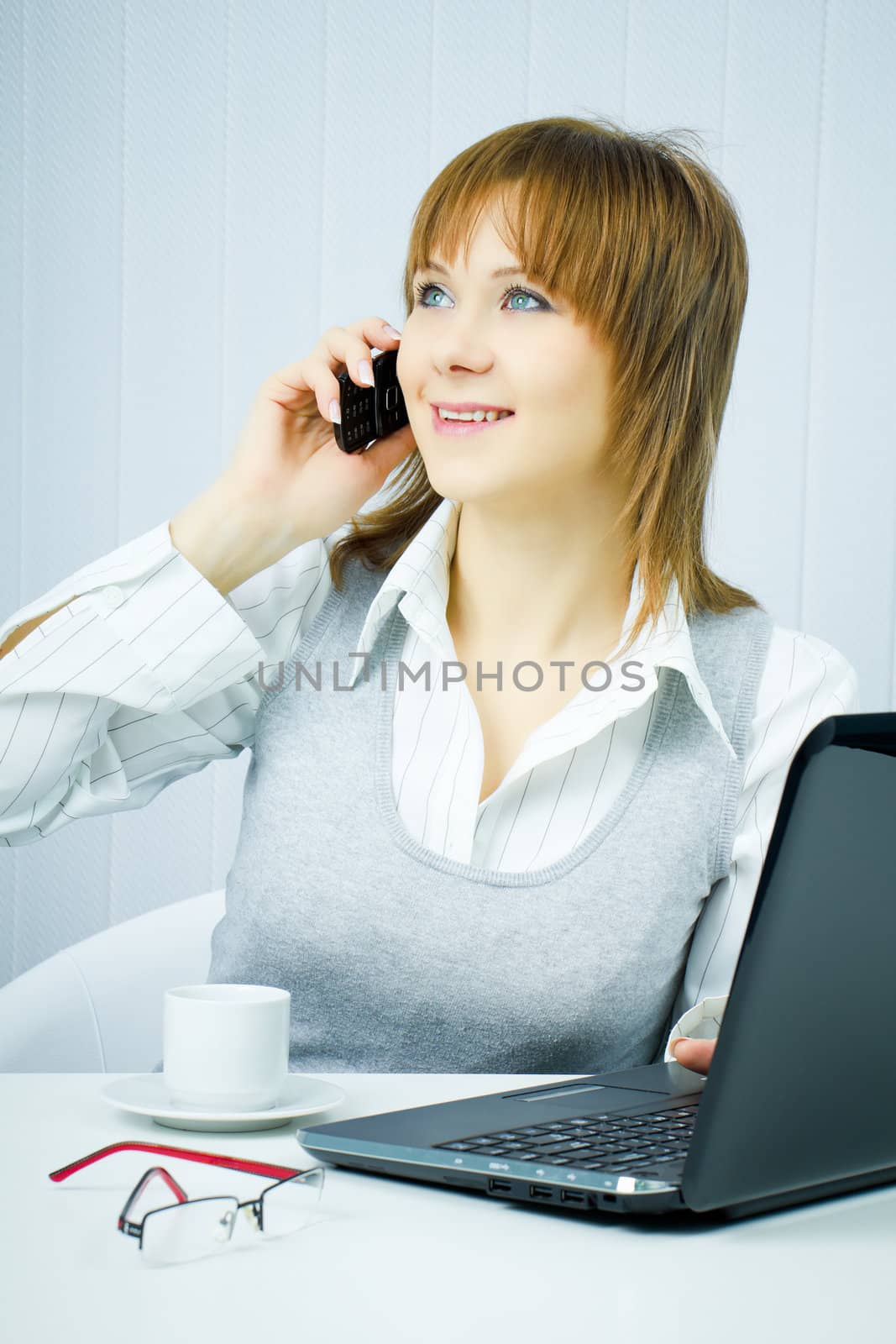 happy business woman in the office talking on the phone
