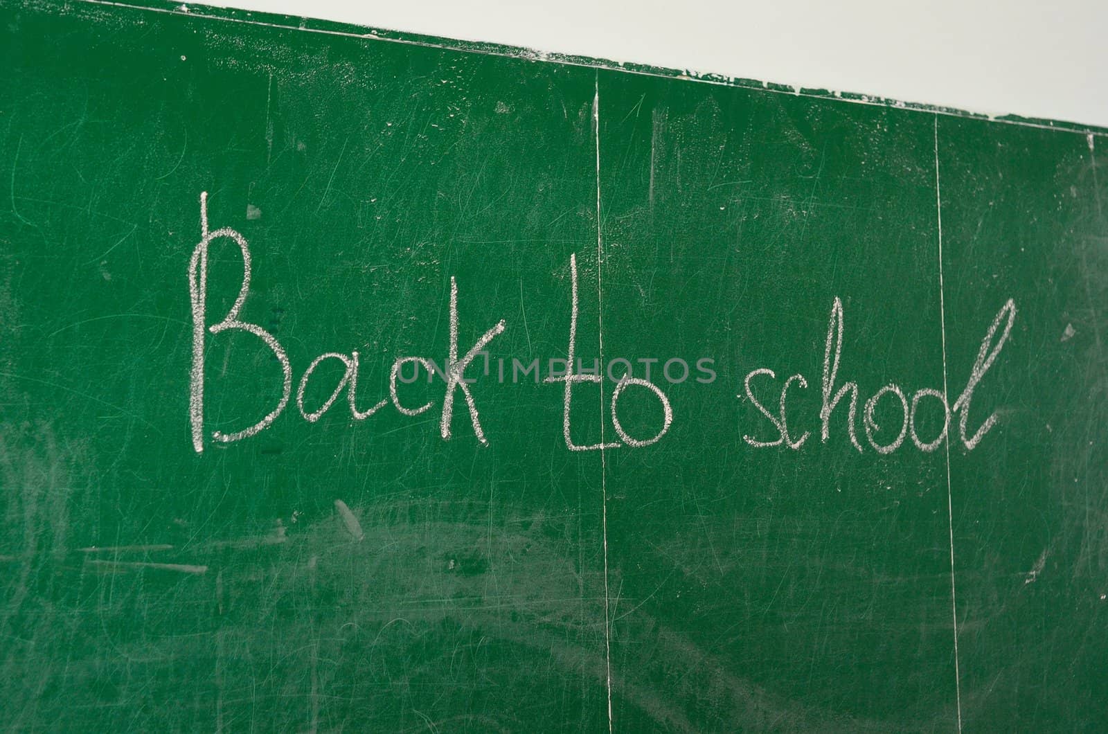 Green chalk blackboard written Back To School with white chalk