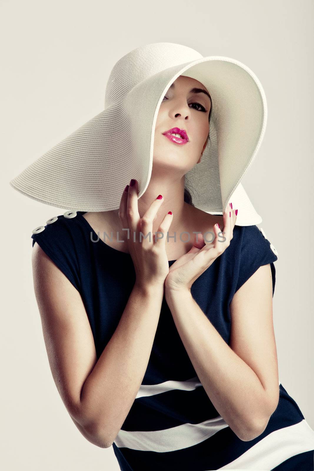 Portrait of a beautiful fashion woman posing with a hat
