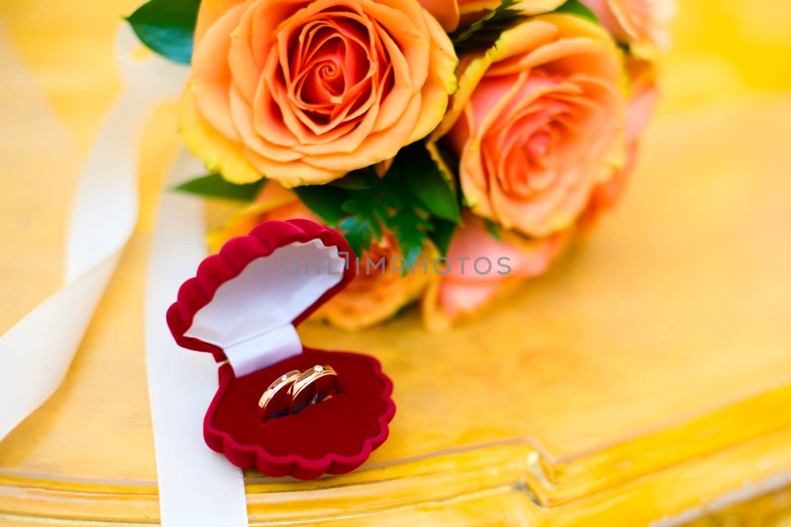 Two new Wedding rings in box with roses bouquet