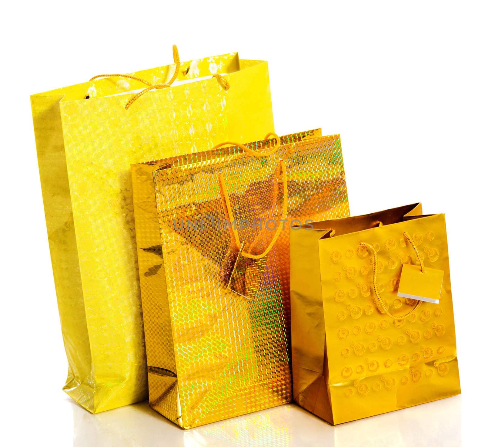 Three yellow paper bags for gifts isolated on white