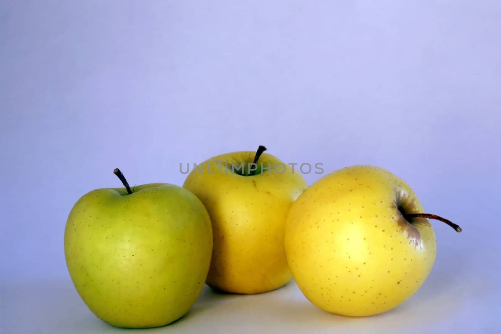 Three apples isolated on blue background