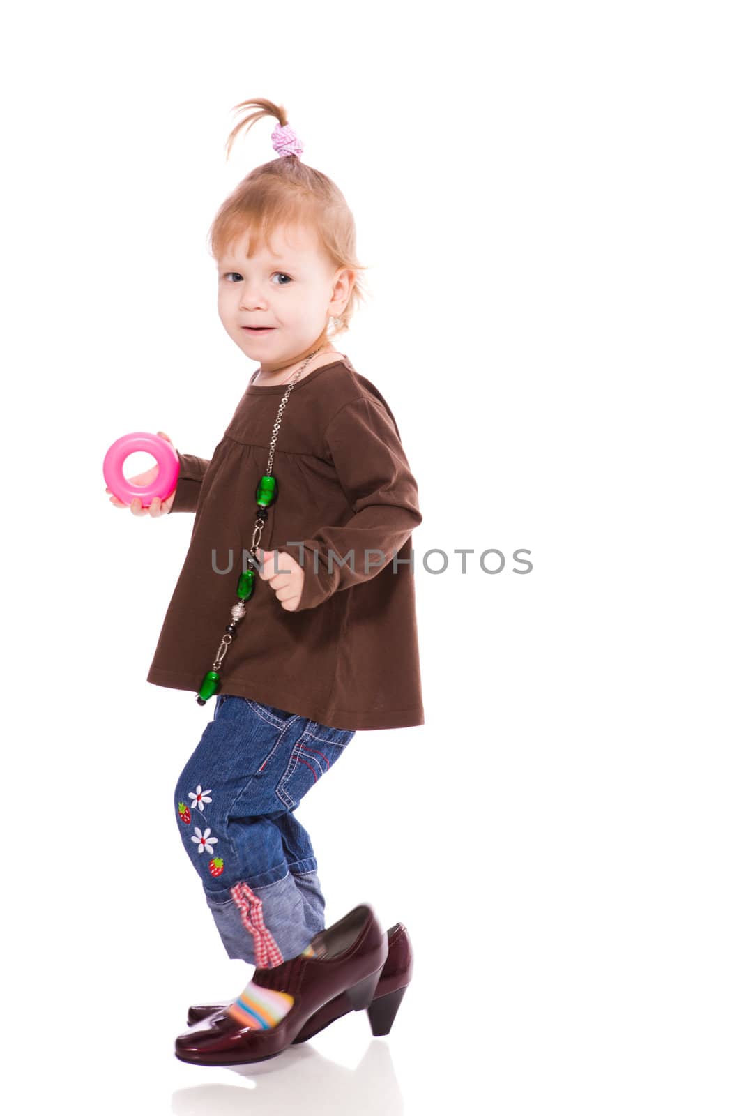 Funny little girl wearing mother's shoes isolated on white