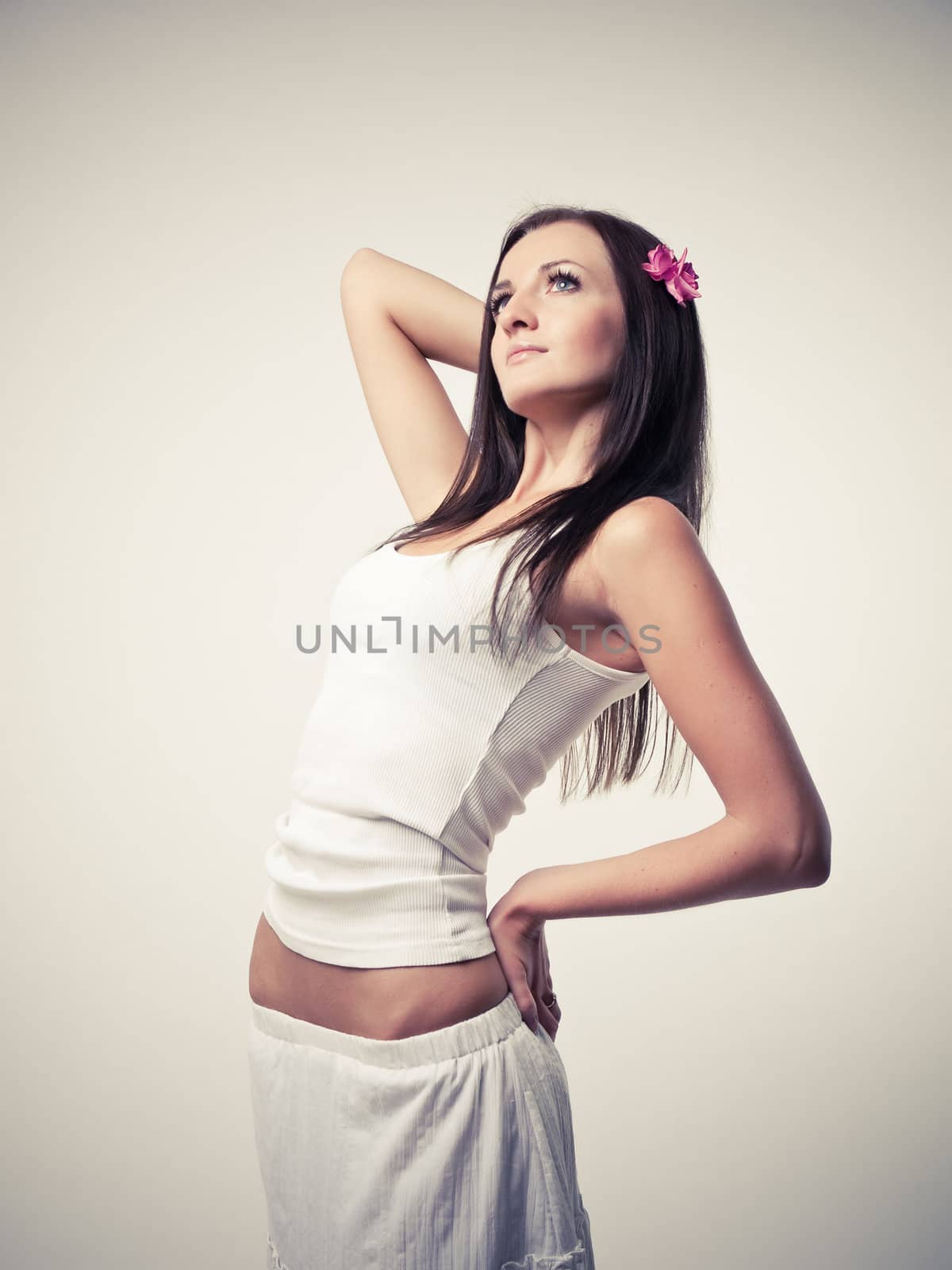 Model in white dress posing in a studio