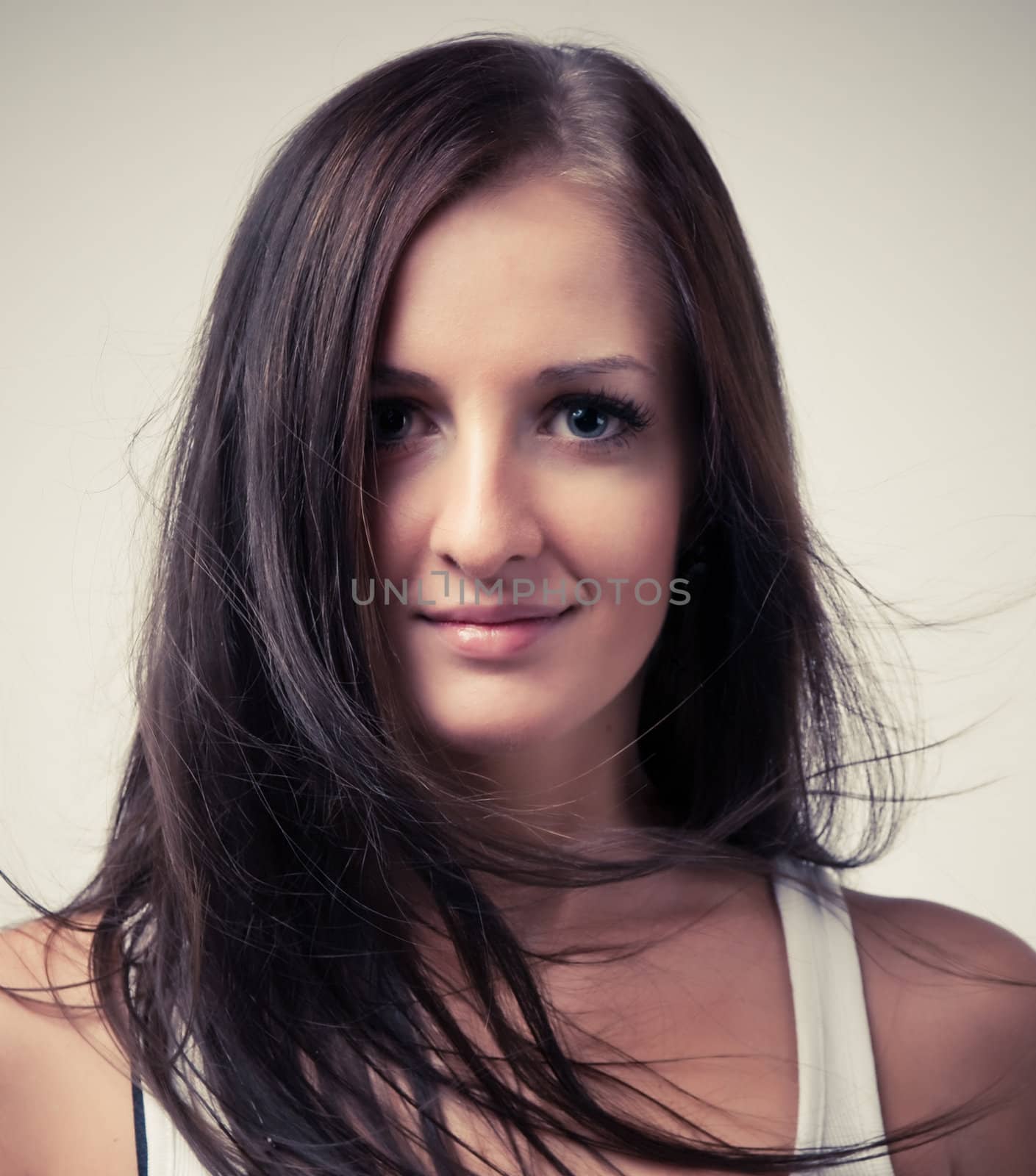Young woman with long hair smiles into the camera