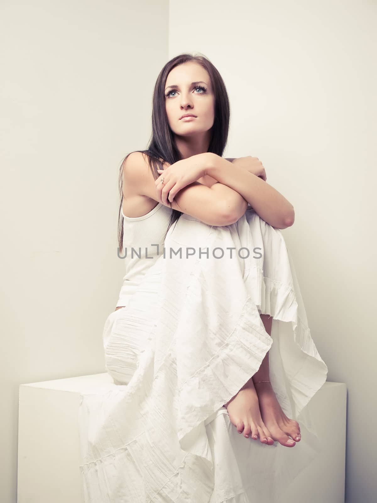 Model in white dress posing in a studio